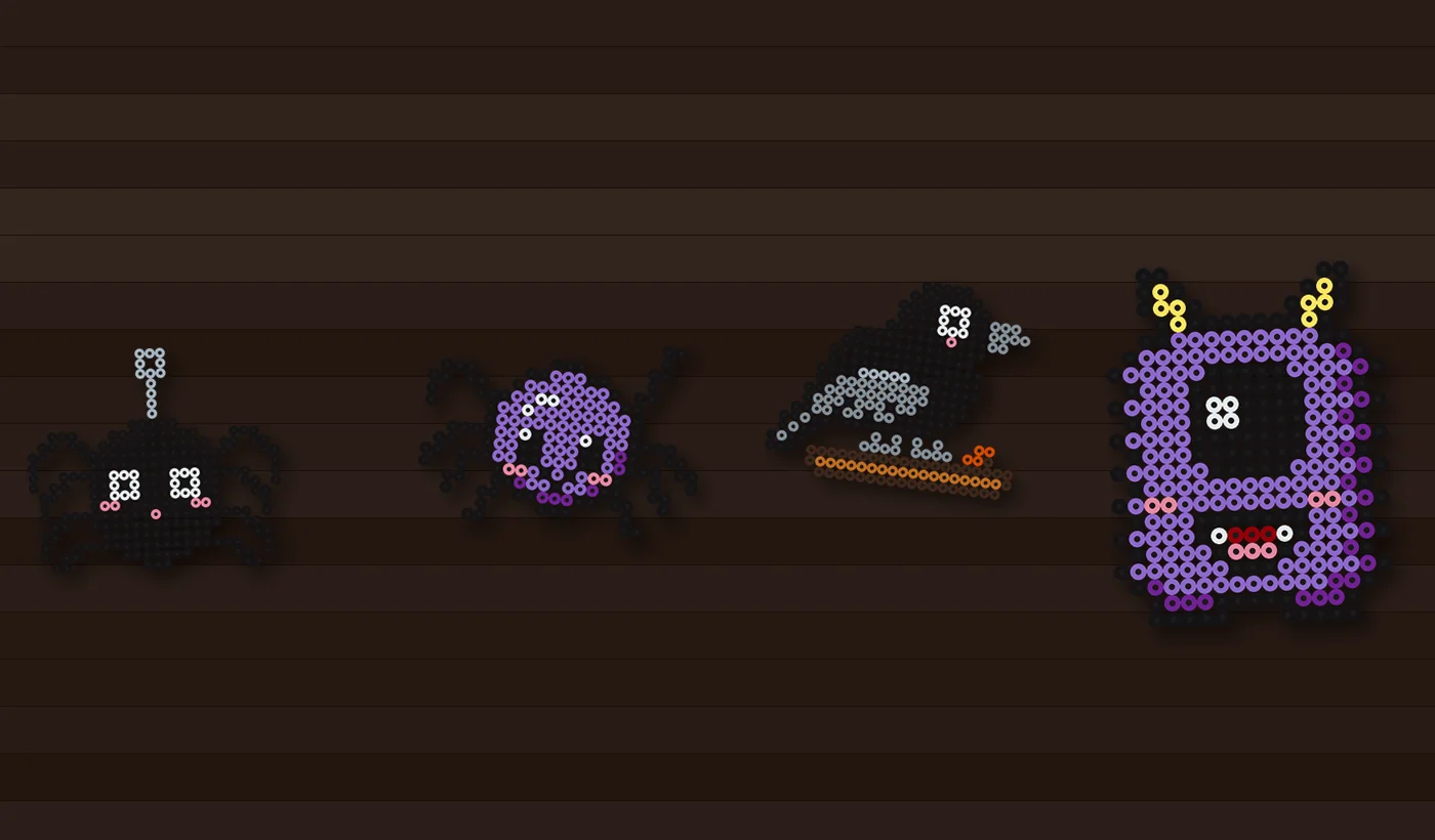 Table d'Halloween dressée avec des marque-places en perles à repasser : araignées, corbeau et monstre à un œil